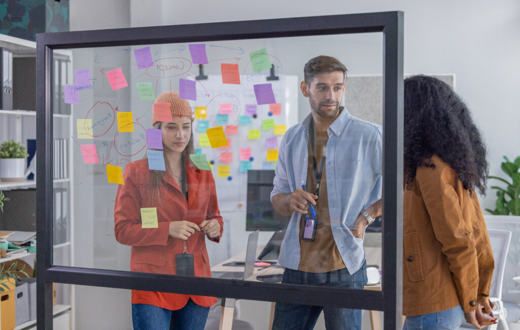 Multicultural startup team brainstorm, exchange ideas, develop fresh perspective by using sticky notes. Working collaboratively as a team help generate innovative idea, potential solution for company